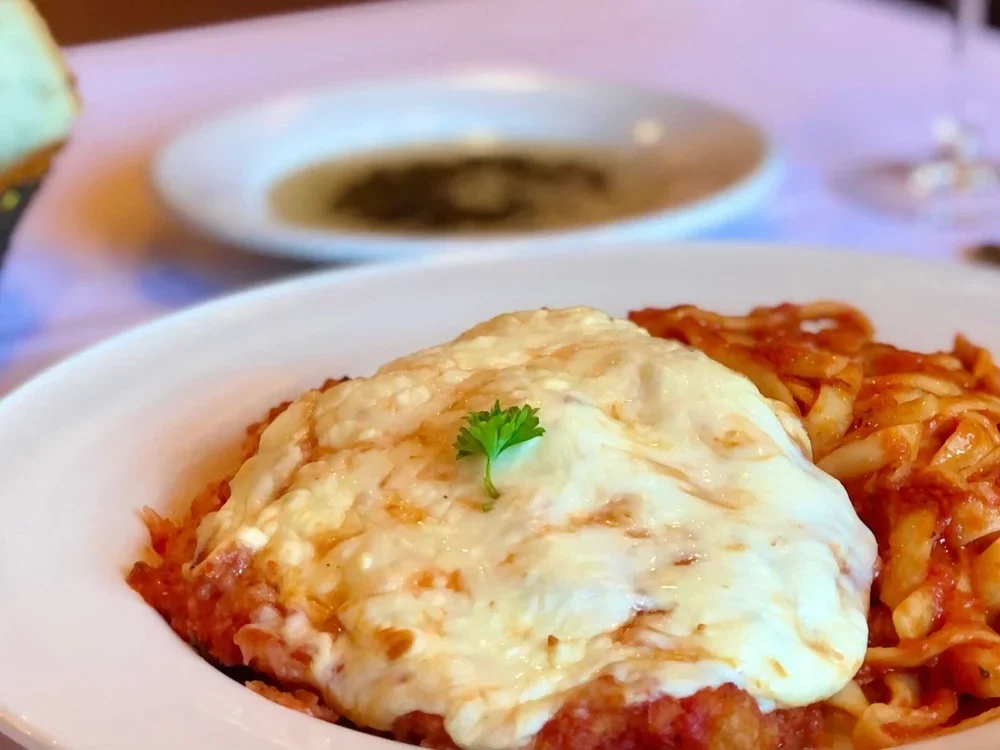 Chicken parmigiano with melted cheese and pasta