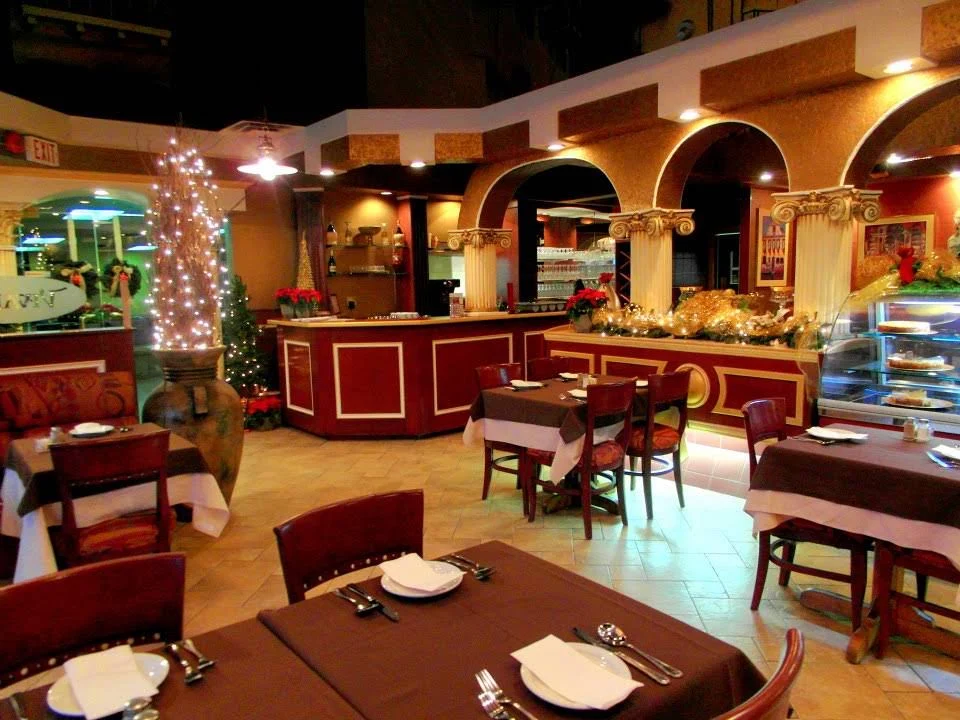 Burgundy chairs, warm lighting, and classical arches in our cozy dining room