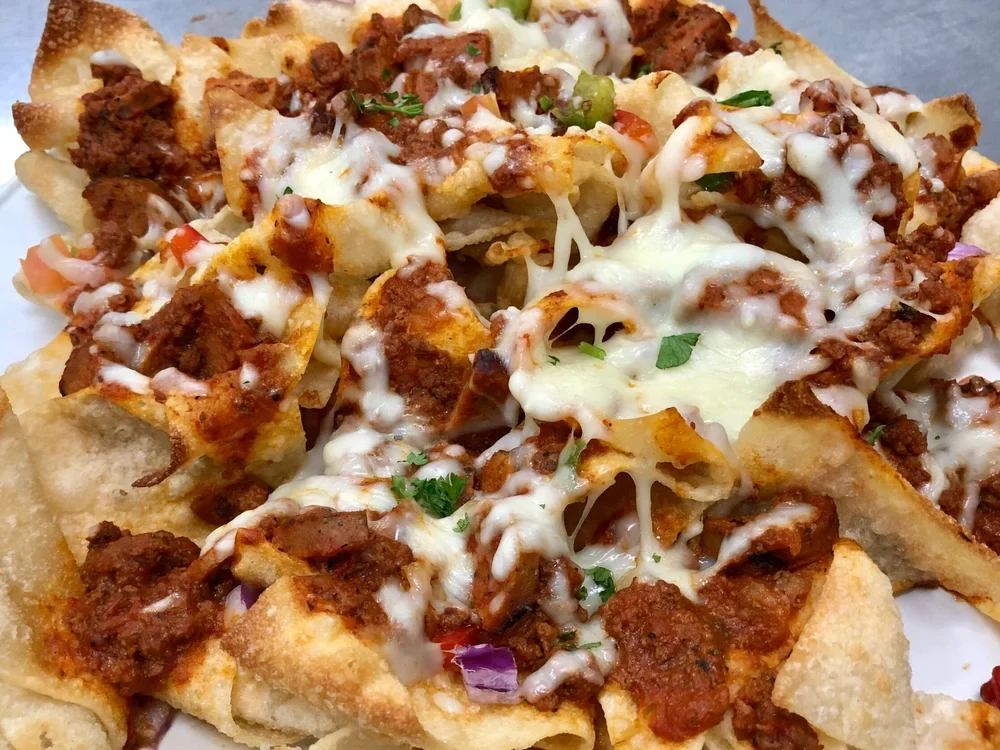House-made pasta chips loaded with sauce and melted cheese